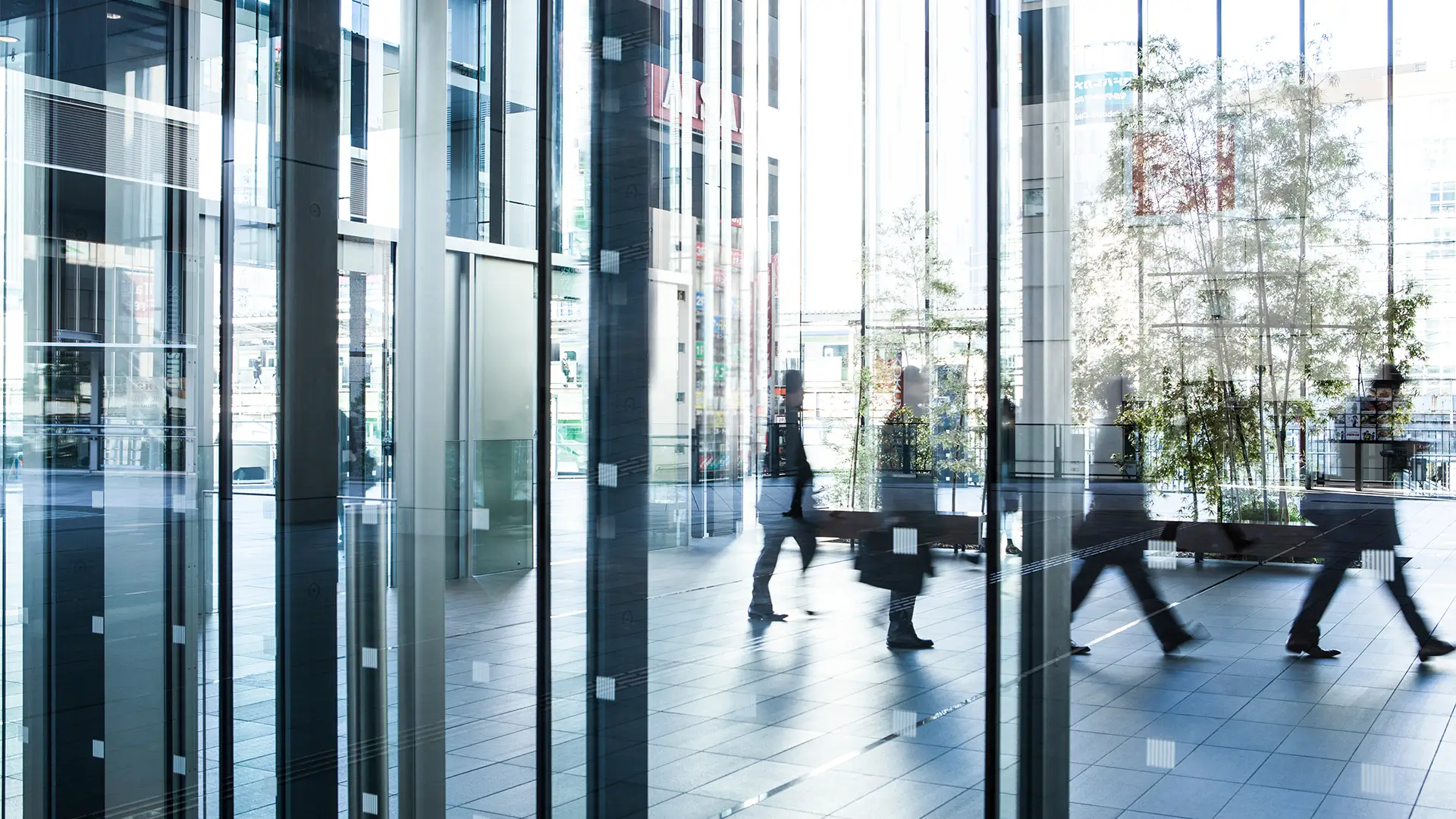 Menschen in moderner Glasarchitektur – Symbol für Fortschritt und dynamische Unternehmensentwicklung