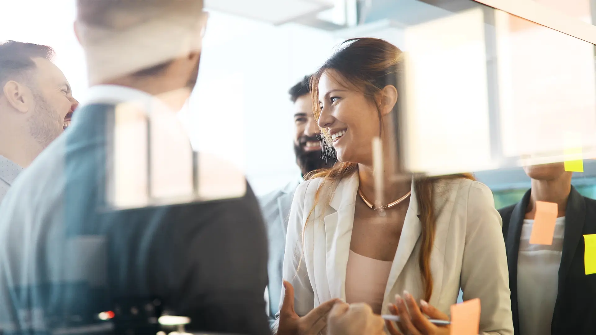 Team im kreativen Austausch mit Post-its – Zusammenarbeit, Innovation und Offenheit in der Unternehmensberatung